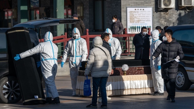 Workers in protective gear handle a coffin and coffin case at Dongjiao Funeral Parlor, reportedly designated to handle Covid fatalities, in Beijing, on Dec. 19.