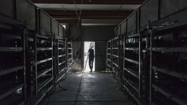 A technician exits a warehouse containing bitcoin mining machines at a mining facility operated by Bitmain Technologies Ltd. in Ordos, Inner Mongolia, China, on Friday, Aug. 11, 2017. Bitmain is one of the leading producers of bitcoin-mining equipment and also runs Antpool, a processing pool that combines individual miners from China and other countries, in addition to operating one of the largest digital currency mines in the world.