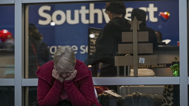 A traveler waits outside the Southwest Airlines baggage office at Oakland International Airport (OAK) in Oakland, California, US, on Wednesday, Dec. 28, 2022. Families hoping to catch a Southwest Airlines Co. flight after days of cancellations, missing luggage and missed family connections suffered through another wave of scrubbed flights, with another 2,500 pulled from arrival and departure boards Wednesday.