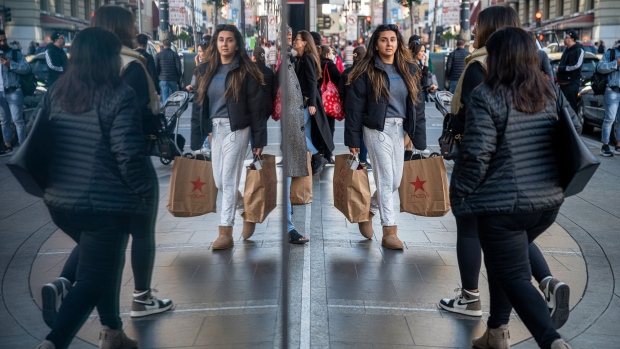 A shopper carries Macy's bags in San Francisco, California, US, on Wednesday, Dec. 21, 2022. US retail sales fell in November by the most in nearly a year, reflecting softness in a range of categories that suggest some easing in Americans' demand for merchandise. Photographer: David Paul Morris/Bloomberg