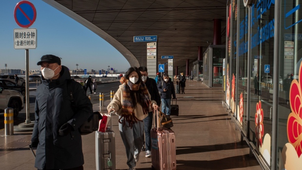 People push their luggage at Beijing Capital International Airport in Beijing, China, on Friday, Dec. 30, 2022. China could see as many as 25,000 deaths a day from Covid-19 later in January, casting a shadow over the start of the first Lunar New Year festivities without pandemic restrictions.