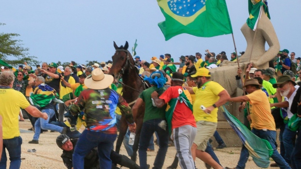 A Military Police officer falls from his horse during clashes with supporters of Brazilian former President Jair Bolsonaro after an invasion to Planalto Presidential Palace in Brasilia on January 8, 2023.