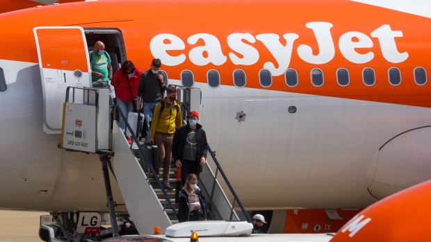 Passengers disembark an Easyjet Plc aircraft at London Luton Airport in Luton, U.K., on Monday, July 19, 2021. While fully vaccinated tourists headed for the Mediterranean were cheered by the removal of quarantine requirements on their return, people bound for France hit out a decision late Friday that means they’ll still need to self-isolate. Photographer: Chris Ratcliffe/Bloomberg