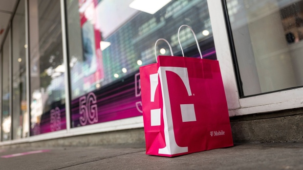 A T-Mobile branded shopping bag in front of a store in San Francisco, California, U.S., on Tuesday, March 16, 2021. T-Mobile US Inc. is kicking off a bond sale to help finance the purchase of new high-speed spectrum licenses as carriers roll out the next generation of mobile devices.