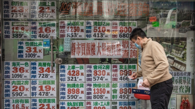 Listings for residential properties for sale at a real estate agency in Hong Kong, China, on Monday, Dec. 5, 2022. The slump in Hong Kong's home prices will deepen next year due to the combination of rising borrowing costs, a recession and an exodus of residents, according to Natixis SA.