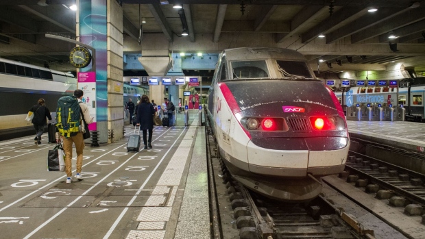 Rail passengers head towards a TGV high-speed train at Gare Montparnasse railway station, during a nationwide strike by SNCF ticket inspectors, in Paris, France, on Friday, Dec. 23, 2022. France's railway unions agreed to end a planned strike that would have disrupted travel over New Year's weekend with a strike today and set to run through Christmas weekend already stranding passengers. Photographer: Nathan Laine/Bloomberg