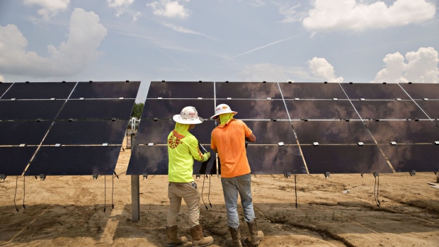 Workers torque mounting brackets on a row of solar panels during construction of a Silicon Ranch Corp. solar generating facility in Milligan, Tennessee, U.S., on Thursday, May 24, 2018. Large oil companies in Europe are continuing to diversify their holdings and increase clean-energy investments. Royal Dutch Shell Plc agreed in January to buy a 44 percent stake in Silicon Ranch Corp., the Nashville-based owner and operator of U.S. solar plants.