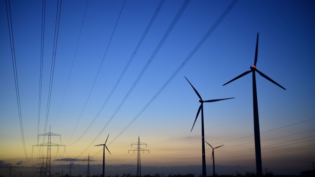 SEHNDE, GERMANY - MARCH 10: High-tension power lines and wind turbines are seen at dawn near a coal-fired Kraftwerk Mehrum power plant at Haemelerwald on March 10, 2015 near Sehnde, Germany. Energy production from conventional-based resources is becoming less profitable as renewable energy production has expanded and matured in Germany in the last decade. RWE, one of Germany's biggest utilities, today warned of pending job cuts due to financial losses derived from its conventional energy production. The Kraftwerk Mehrum plant is majority-owned by Stadtwerke Hannover AG. (Photo by Alexander Koerner/Getty Images)