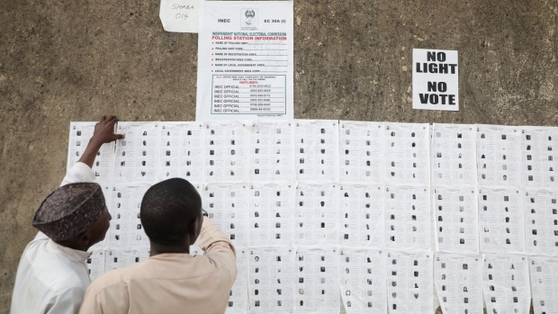 People check their names on the electoral roll ahead of casting their votes at a polling station in Kaduna. Photographer: Kola Sulaimon/AFP/Getty Images