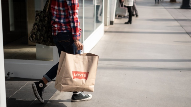 A shopper carries a Levi Strauss & Co. bag on the Third Street Promenade in Santa Monica, California, on Friday, Nov. 16, 2018. Levi's the ubiquitous U.S. jeans maker, is looking to raise $600 million to $800 million in an initial public offering. Photographer: Martina Albertazzi/Bloomberg
    