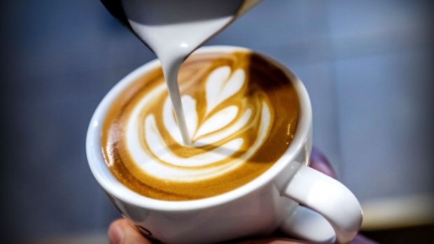 An employee pours a latte art into a cup of coffee at the Roastery Lab by Coffee Academics research and development facility, operated by Coffee Academics Group Holdings Ltd., in Hong Kong, China, on Thursday, July 27, 2017. Coffee Academics operates seven coffee outlets in Hong Kong.