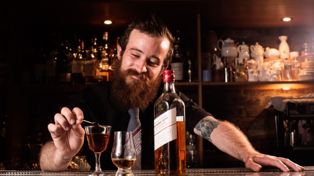 A bartender makes a Scotch cocktail as a bottle of Johnnie Walker Bledners' Batch Red Rye Finish, a blended scotch whisky sits on the counter at the Bon Vivant bar in Edinburgh, U.K., on Thursday. Sept. 29, 2016. Johnnie Walker, made by Diageo Plc, accounts for about one in every 10 bottles of Scotch consumed across the world. Photographer: Matthew Lloyd/Bloomberg