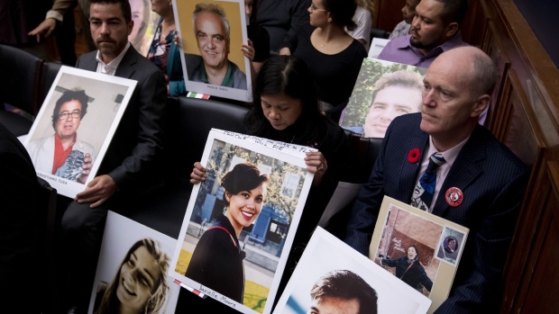 Family members of Boeing Co. 737 Max crash victims hold photographs before the start of a House Transportation and Infrastructure Committee hearing in Washington, D.C., U.S., on Wednesday, Oct. 30, 2019. Boeing Co. Chief Executive Officer Dennis Muilenburg yesterday declined to endorse specific reforms to bolster safety oversight of the aerospace giant during a sometimes angry grilling in his first appearance before Congress since two 737 Max crashes killed 346 people.