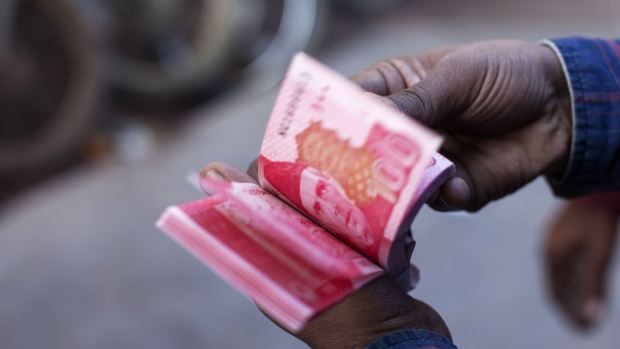 A roadside money changer counts Pakistani one hundred rupee banknotes at a currency exchange market in Karachi, Pakistan, on Thursday, Dec. 14, 2017. Pakistan's rupee weakened to a record low after the central bank continued to ease its grip on the currency amid mounting economic pressure and speculation that the country may need International Monetary Fund support. Photographer: Asim Hafeez/Bloomberg