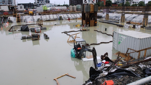 AUCKLAND, NEW ZEALAND - JANUARY 28: A digger is submerged in a flooded construction site in the Wynyard Quarter the morning after record heavy rain on January 28, 2023 in Auckland, New Zealand. (Photo by Lynn Grieveson/Getty Images)