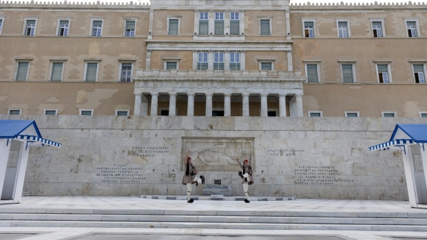 Presidential guards perform their ceremonial duties in front of the Greek parliament building in Syntagma square, ahead of a debate on phone tapping, in Athens, Greece, on Friday, Aug. 26, 2022. The Greek government and the European Union should move faster on probes over surveillance of an opposition politician and a journalist, a senior European lawmaker said, as the scandal threatens further domestic turmoil. Photographer: Yorgos Karahalis/Bloomberg