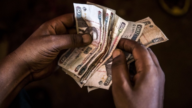 A market trader counts Kenyan shilling banknotes at a market stall in Mombasa, Kenya, on Thursday, Nov. 23, 2017. The country’s Treasury has already cut this year’s growth target to 5 percent from 5.9 percent as the protracted election furor damped investment and a drought curbed farm output.