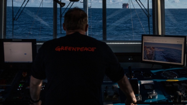 GRAN CANARIA, SPAIN - JANUARY 31: Captain of Greenpeace ship Arctic Sunrise looks out to the White Marlin ship transporting a Shell oil platform after being boarded by activists on January 31, 2023 in the Atlantic Ocean north of Gran Canaria, Spain. Greenpeace activists from Argentina, Turkey, the US and the UK have boarded and occupied the Shell oil platform en route to a major oilfield in the North Sea with the message: STOP DRILLING. START PAYING. Just two days ahead of Shells profits announcement, four Greenpeace International activists boarded the White Marlin vessel at sea north of the Canary Islands in a peaceful protest against the climate devastation around the world caused by Shell and the wider fossil fuel industry, without paying a penny towards loss and damage. (Photo by Handout/Getty Images)