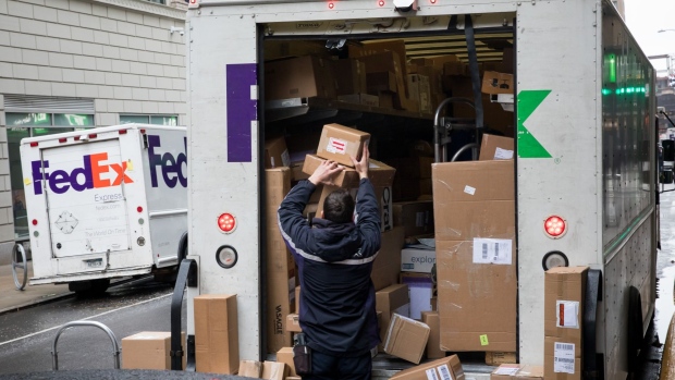 An independent contractor to FedEx Corp. unloads packages from a delivery truck on Cyber Monday in New York, U.S., on Monday, Dec. 2, 2019. The optics war between Amazon.com Inc. and its critics is intensifying on Cyber Monday with labor, environmental and digital privacy groups staging events around the globe to amplify their concerns about the world’s biggest online retailer. Photographer: Michael Nagle/Bloomberg