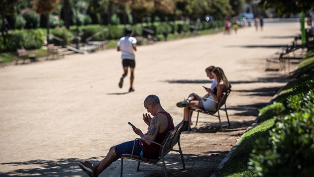 Visitors rest on benches in the shade of trees at Ciutadella Park, a designated climatic refuge, part of Barcelona’s Climate Shelter Network (CSN), where residents can take shelter during extreme heat, in Barcelona, Spain, on Wednesday, Aug. 3, 2022. Recent heat waves have sparked deadly wildfires in Spain, Portugal and France, adding to the challenges facing Europe from political upheaval to travel chaos and surging prices.