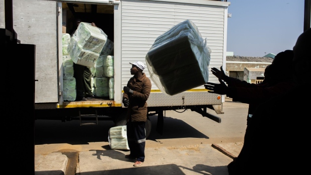 Workers from Kasi Convenience unload a delivery from a truck in the Soweto district of Johannesburg, South Africa, on Thursday, Aug. 3, 2020. Seven months of lockdown regulations have slammed South Africa’s economy and prolonged a recession the government was struggling to reverse before the pandemic hit. Photographer: Waldo Swiegers/Bloomberg