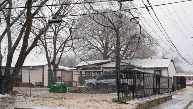 A fallen power line in front of a home following an ice storm in Dallas, Texas, US, on Thursday, Feb. 2, 2023. Texas will face a fourth day grappling through an ice storm that has caused power outages, grounded flights and triggered deadly accidents on slippery roads.