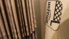 An Amazon.com Inc. logo sits on cardboard packaging at the company's fulfillment center in Peterborough, UK
