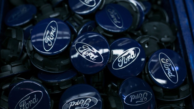 The Ford Motor Co. logo sits on wheel hub badges on the Ford Focus assembly line inside the automaker's factory in Saarlouis, Germany, on Wednesday, Sept. 25, 2019. Ford recently announced it expects 'electrified' vehicles which include mild hybrids, traditional hybrids, plug-in electric hybrids (PHEVs) and battery electric vehicles (BEVs) to make up over 50% of its passenger vehicle sales by year-end 2022. Photographer: Krisztian Bocsi/Bloomberg