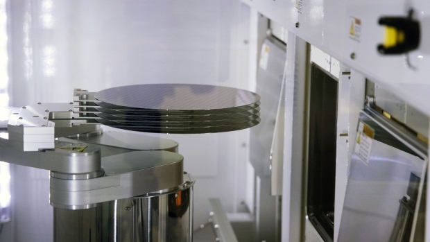 A robotic arm moves 300 mm silicon semiconductor wafers inside a sorting machine in a cleanroom at the Globalfoundries Inc. semiconductor fabrication plant in Dresden, Germany, on Wednesday, Nov. 30, 2022. As the US has implemented unexpectedly strict rules on the transfer of semiconductor technology to China, the EU has paved the way for chipmakers to receive unprecedented state funds to build production sites as part of its EU Chips Act. Photographer: Liesa Johannssen/Bloomberg