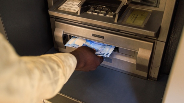 A customer withdraws newly-designed Nigerian 1000 naira banknotes from an automated teller machine (ATM) in Lagos, Nigeria, on Monday, Feb. 6, 2023. Central Bank Governor Godwin Emefiele has defended his decision to replace 2.7 trillion naira ($5.85 billion) of cash outside the banking system even as scenes of chaos have unfolded all over Nigeria, where the vast majority of transactions are still done in cash. Photographer: Benson Ibeabuchi/Bloomberg