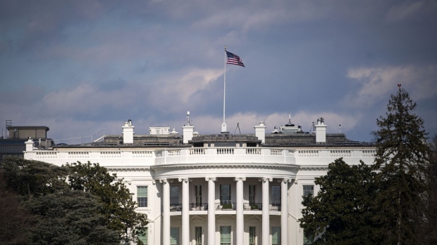 An American flag flies outside the White House in Washington, D.C., U.S., on Friday, Jan. 22, 2021. President Joe Biden will mark his third day in office with executive actions to boost food assistance for impoverished Americans and use federal contracts as a step toward his proposed nationwide minimum-wage hike, seeking immediate help for an economy struggling to cope with Covid-19.