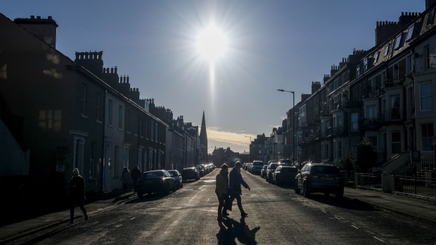 Pedestrians cross a residential street in Whitby, U.K., on Sunday, Jan. 19, 2020. The fate of one of the Bank of England's trickiest interest-rate decision in years is in the balance, sharpening the focus on the nine policy makers whose votes will impact the cost of borrowing for millions of Britons. Photographer: Ian Forsyth/Bloomberg