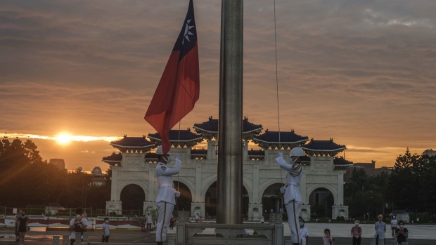Soldiers lower the Taiwanese flag during a ceremony at the Chiang Kai-shek Memorial Hall in Taipei, Taiwan. on Thursday, Aug. 4, 2022. China's military fired missiles into the sea on Thursday in live-fire military exercises around the island in response to US House Speaker Nancy Pelosi's visit, even as Taipei played down the impact on flights and shipping. Photographer: Lam Yik Fei/Bloomberg