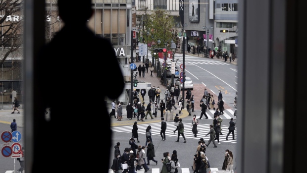Pedestrians cross an intersection in the Shibuya district of Tokyo, Japan, on Wednesday, Feb. 17, 2021. Bank of Japan Governor Haruhiko Kuroda says it will be hard for the bank to attain its price target even in 2023, hinting at the need to keep monetary easing rolling long after his current term ends. Photographer: Kiyoshi Ota/Bloomberg