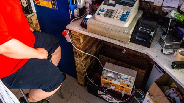 Cafe workers use an inverter battery back-up system to supply power to the cash till after electricity was shut off during a load-shedding power outage in Johannesburg, South Africa, on Thursday, Feb. 14, 2019. Eskom Holdings SOC Ltd. cut supplies for the fifth day on Thursday and warned its power generation system remains "vulnerable."