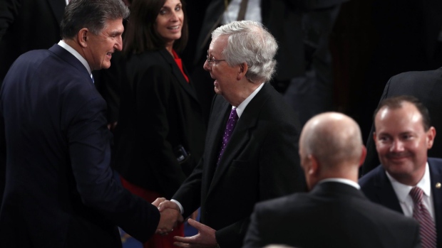 Senate Majority Leader Mitch McConnell, a Republican from Kentucky, center, shakes hands with Senator Joe Manchin, a Republican from West Virginia, left, ahead of a State of the Union address to a joint session of Congress at the U.S. Capitol in Washington, D.C., U.S., on Tuesday, Feb. 4, 2020. President Donald Trump will try to move past his impeachment and make a case for his re-election in Tuesday's State of the Union address by taking credit for a strong economy, newly signed trade deals and an immigration crackdown. Photographer: Andrew Harrer/Bloomberg