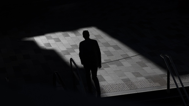 A silhouetted pedestrian outside a train station in Sydney, Australia, on Wednesday, Dec. 29, 2021. Hospitalizations due to coronavirus in Australia’s most-populous state have reached the highest level since mid-October, as a surge in omicron cases throughout most of the nation pressures the health system. Photographer: Brent Lewin/Bloomberg