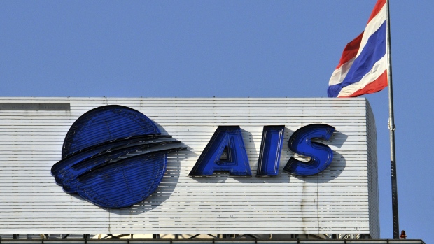 The Thai national flag flies atop the headquarters of AIS in downtown Bangkok. Photographer: Udo Weitz/Bloomberg