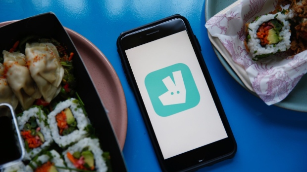 The Deliveroo logo is displayed on a smartphone between dishes of delivered sushi in this arranged photograph in London, U.K., on Tuesday, Aug. 11, 2020. Just Eat Takeaway.com NV are due to report earnings on Aug. 12.