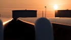 The sun rises beyond oil storage tanks. Photographer: Daniel Acker/Bloomberg