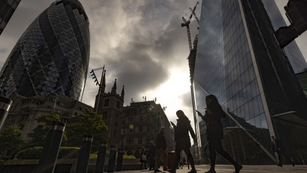 Morning commuters walk past skyscrapers including 30 St. Mary Axe, also known as The Gherkin, left, in the City of London, UK, on Monday, May 16, 2022. The Office for National Statistics (ONS) will release the latest UK Labor Market Statistics on Tuesday. Photographer: Jason Alden/Bloomberg