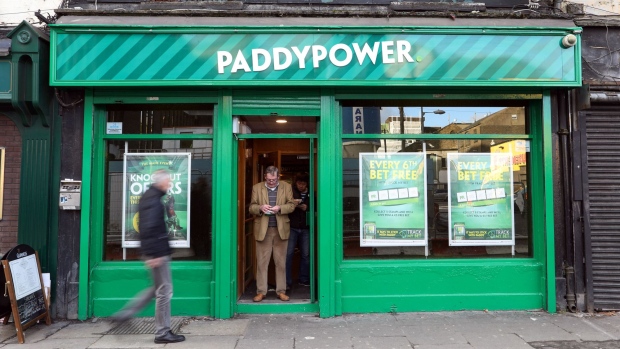 A customer stands in the doorway of a Paddy Power Betfair Plc betting shop in Dublin, Ireland, on Thursday, Nov. 24, 2016. Irish ministers and executives are closely monitoring economic and market developments in the U.K. because the country is Ireland’s largest trading partner along with the U.S. Photographer: Chris Ratcliffe/Bloomberg