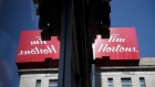 Tim Hortons Inc. signage is reflected in a window outside a store in Montreal, Quebec, Canada, on Monday, Aug. 20, 2018. Median single-family home prices in Montreal rose 5.7% to C$336,250 in July from a year ago, according to the Greater Montreal Real Estate Board (GMREB). Photographer: Brent Lewin/Bloomberg