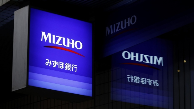 Illuminated signage for Mizuho Bank Ltd., a unit of Mizuho Financial Group Inc. (MHFG), displayed outside a branch at night in Tokyo, Japan, on Wednesday, Jan. 25, 2023. Japan's mega banks are scheduled to release its third-quarter earnings figures next week. Photographer: Kiyoshi Ota/Bloomberg