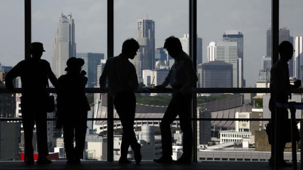 People stand at a window of an observation deck in Tokyo, Japan, on Monday, Sept. 28, 2015.  Photographer: Tomohiro Ohsumi/Bloomberg
