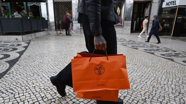 A shopper carries Hermes International bags in Lisbon, Portugal, on Tuesday, Dec. 6, 2022. Inflation in the European Union is reaching its peak, according to Economy Commissioner Paolo Gentiloni. Photographer: Zed Jameson/Bloomberg