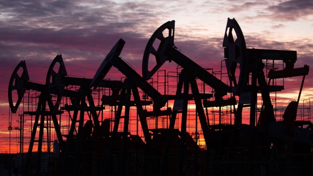 Oil pumping jacks in an oil field at sunset in Russia.