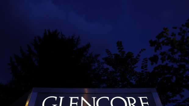 Signage stands illuminated at night near the Glencore Plc headquarters office in Baar, Switzerland, on Friday, July 6, 2018. Glencore will buy back as much as $1 billion of its shares, a move that may soothe investor concerns after the worlds top commodity trader was hit by a U.S. Department of Justice probe earlier this week. Photographer: Stefan Wermuth/Bloomberg
