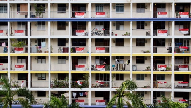 Singapore national flags hang from corridor balustrades at a public housing block in the Kallang area of Singapore, on Sunday, Sept. 18, 2016. Singapore is currently mired in its most prolonged housing slump on record. Home prices in the city-state fell for the 11th straight quarter in the three months ending June 30, posting the longest losing streak since records started in 1975. Photographer: SeongJoon Cho/Bloomberg