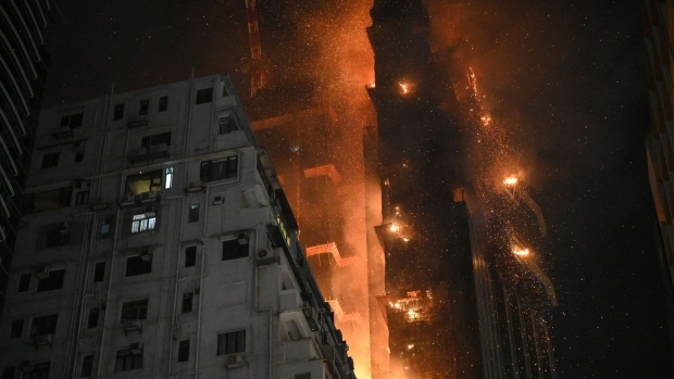 A fire burns at a high-rise building under construction in the Tsim Sha Tsui district on March 3. Photographer: Peter Parks/AFP/Getty Images